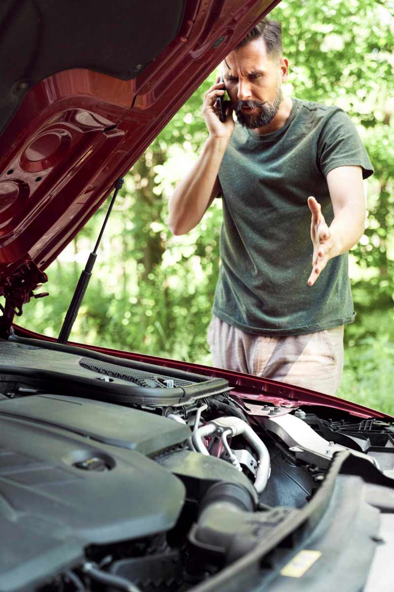 Junger Mann prüft Getriebeschaden bei Schrottauto Ankauf Itzehoe